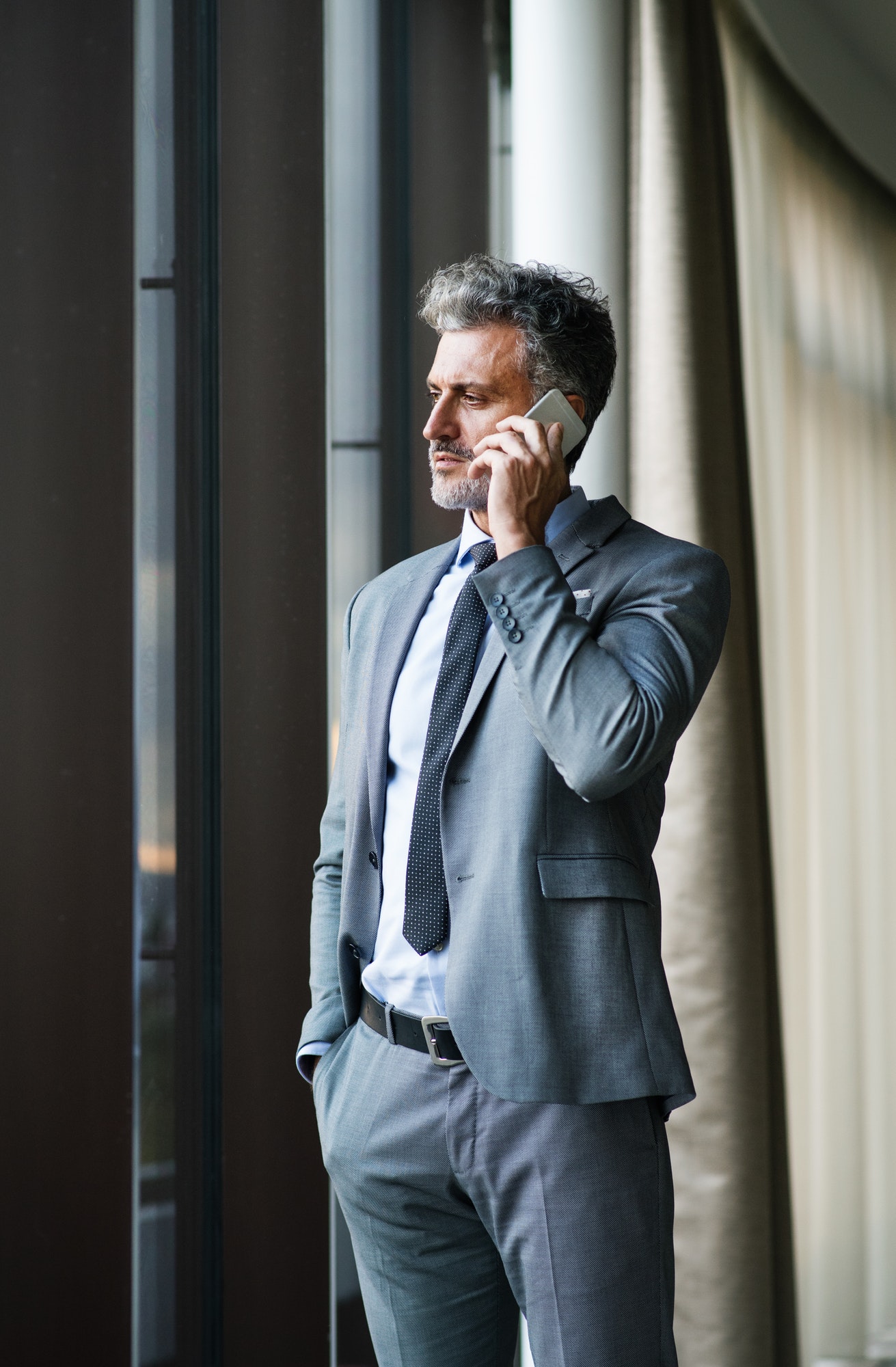 Mature businessman with smartphone in a hotel.