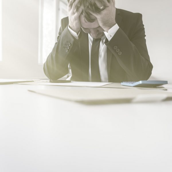 Despairing businessman with his head in his hands